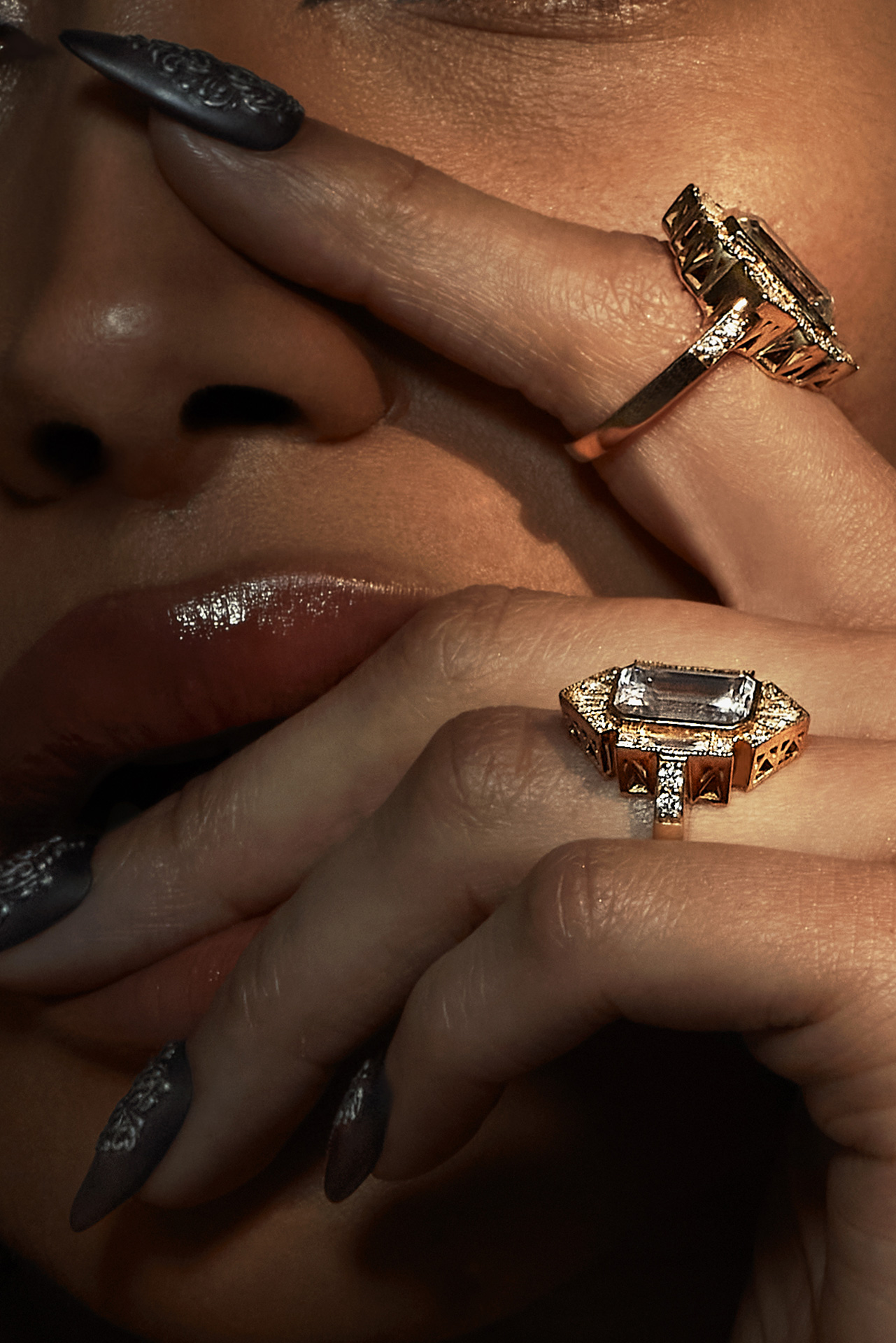 Close-up view of Ahvonnah Viney partially covering her face with her hands, highlighting the rings and detailed nail art.